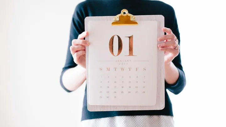 Calendário com datas marcadas ao lado de um caderno de anotações